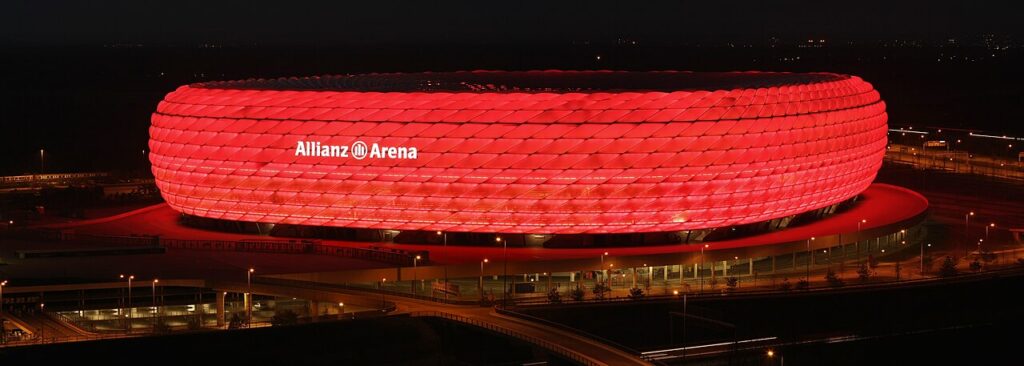 Allianz Arena at night seen from above, glowing red