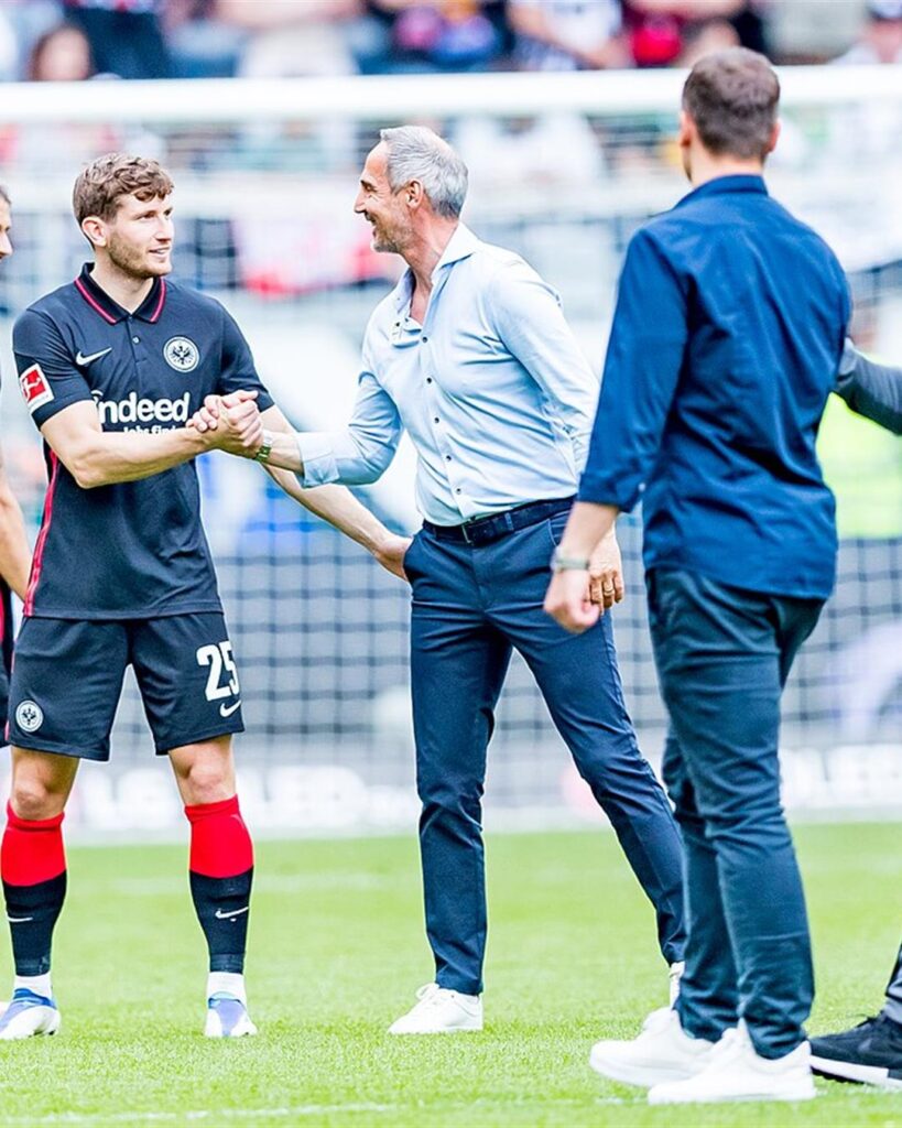 Adi Hütter shaking hands with an Eintracht Frankfurt player after a game at the Frankfurt stadium