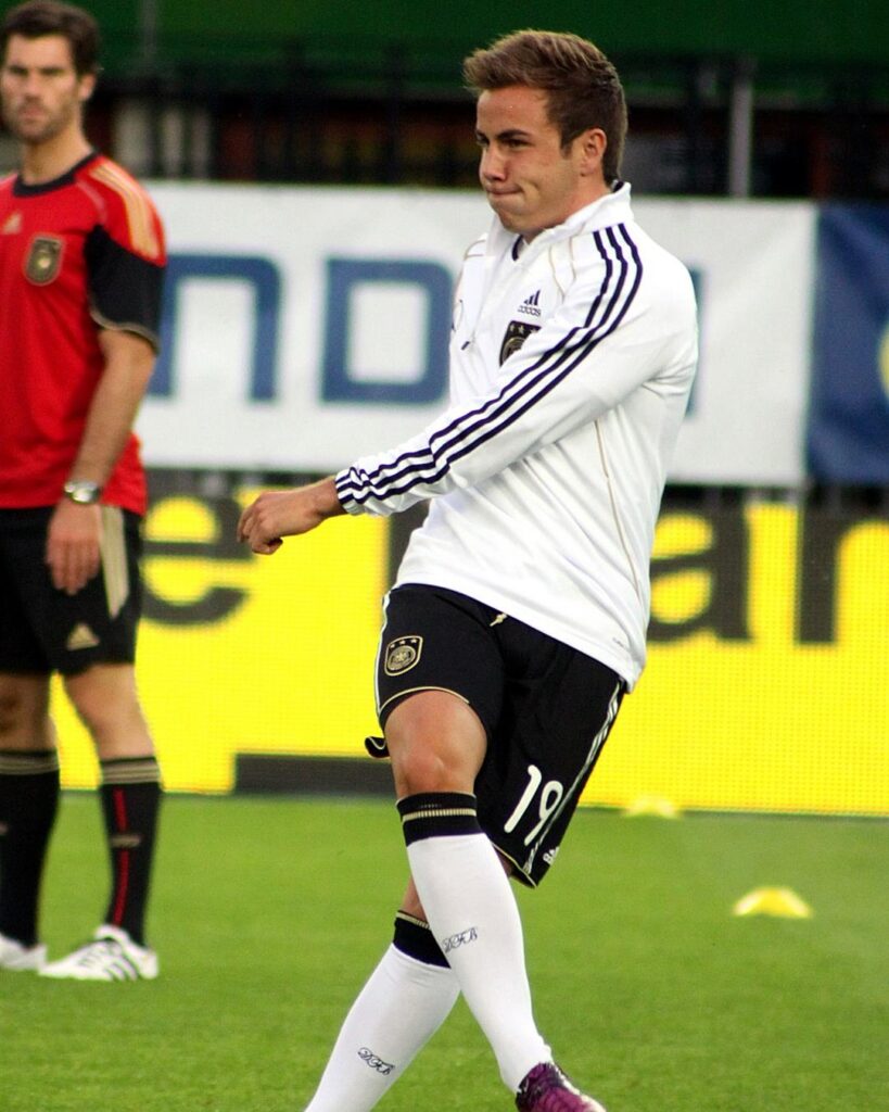 Mario Götze in a white Germany training top warming up before a game