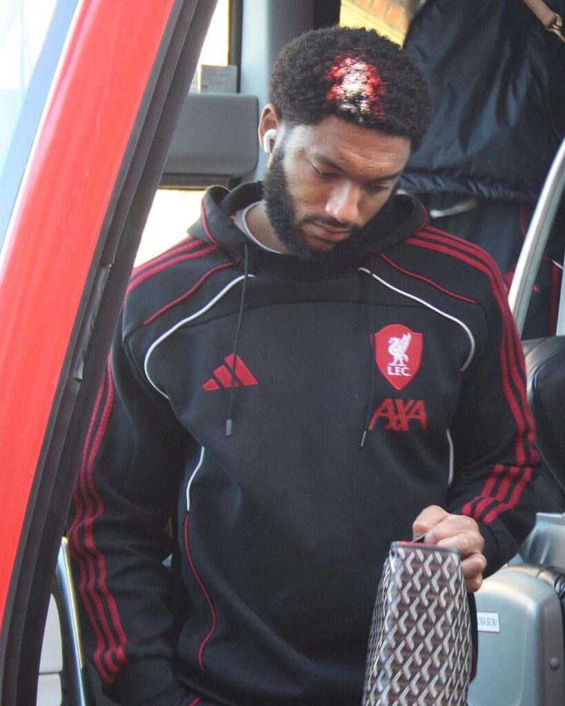 Joe Gomez in a black Liverpool hoodie, stepping off the team bus
