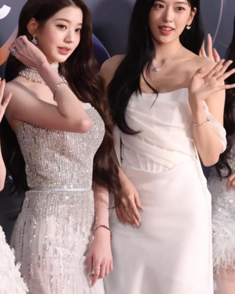 Jang Won-young and an IVE bandmate in white gowns on the red carpet at the 2026 Golden Disc Awards