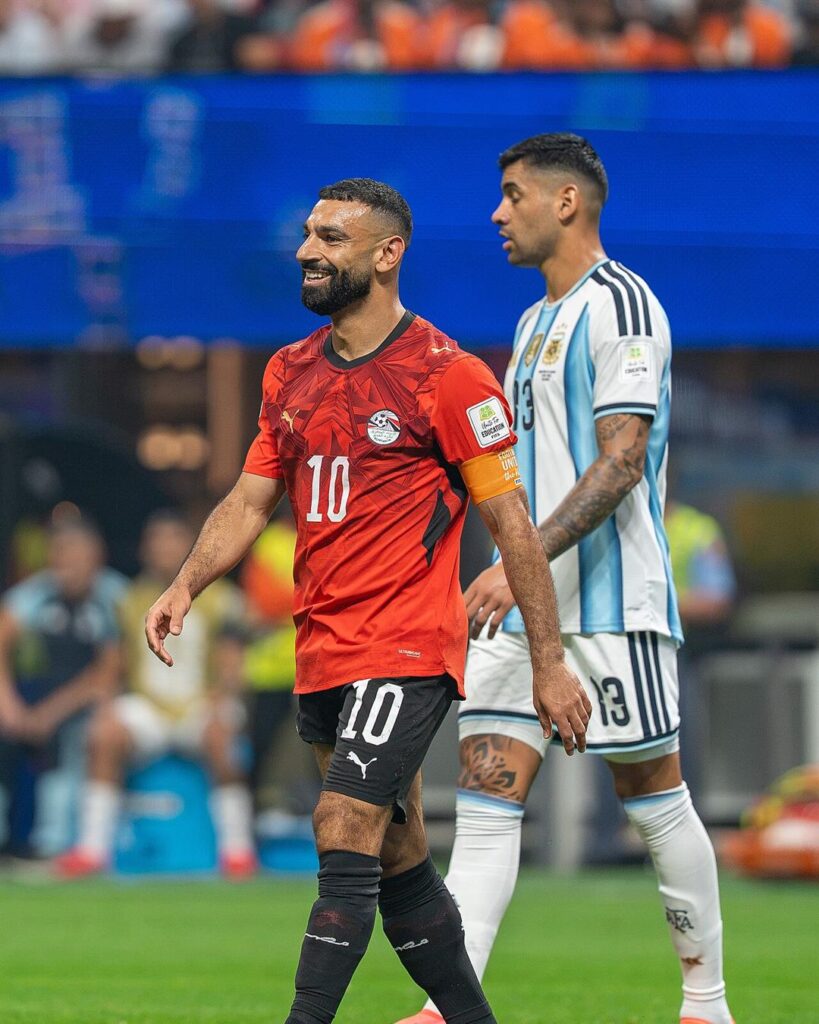 Mohamed Salah smiling in a red Egypt shirt with the number 10 and captain's armband