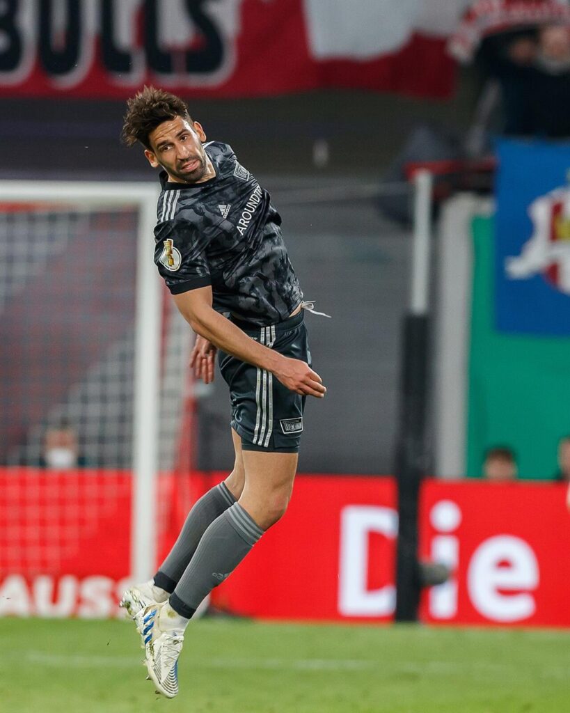 Rani Khedira jumping for a header in a dark Union Berlin kit during a German Cup game
