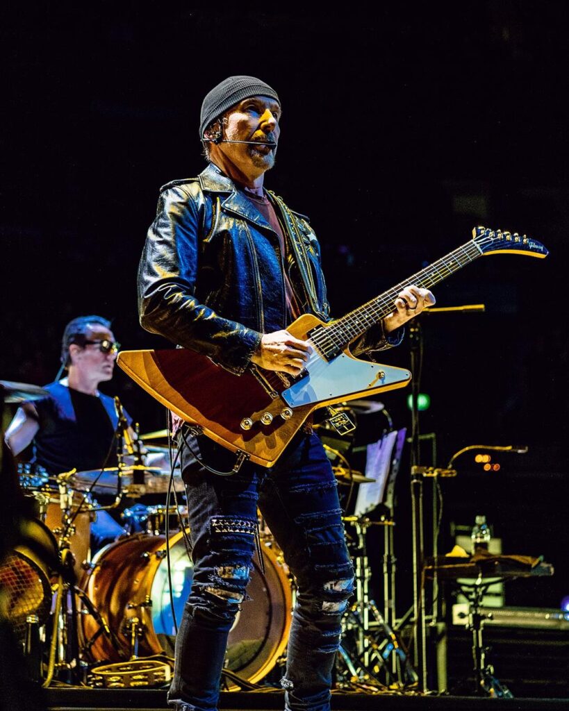 The Edge in a grey beanie playing a Gibson guitar on stage in Hamburg, 2018